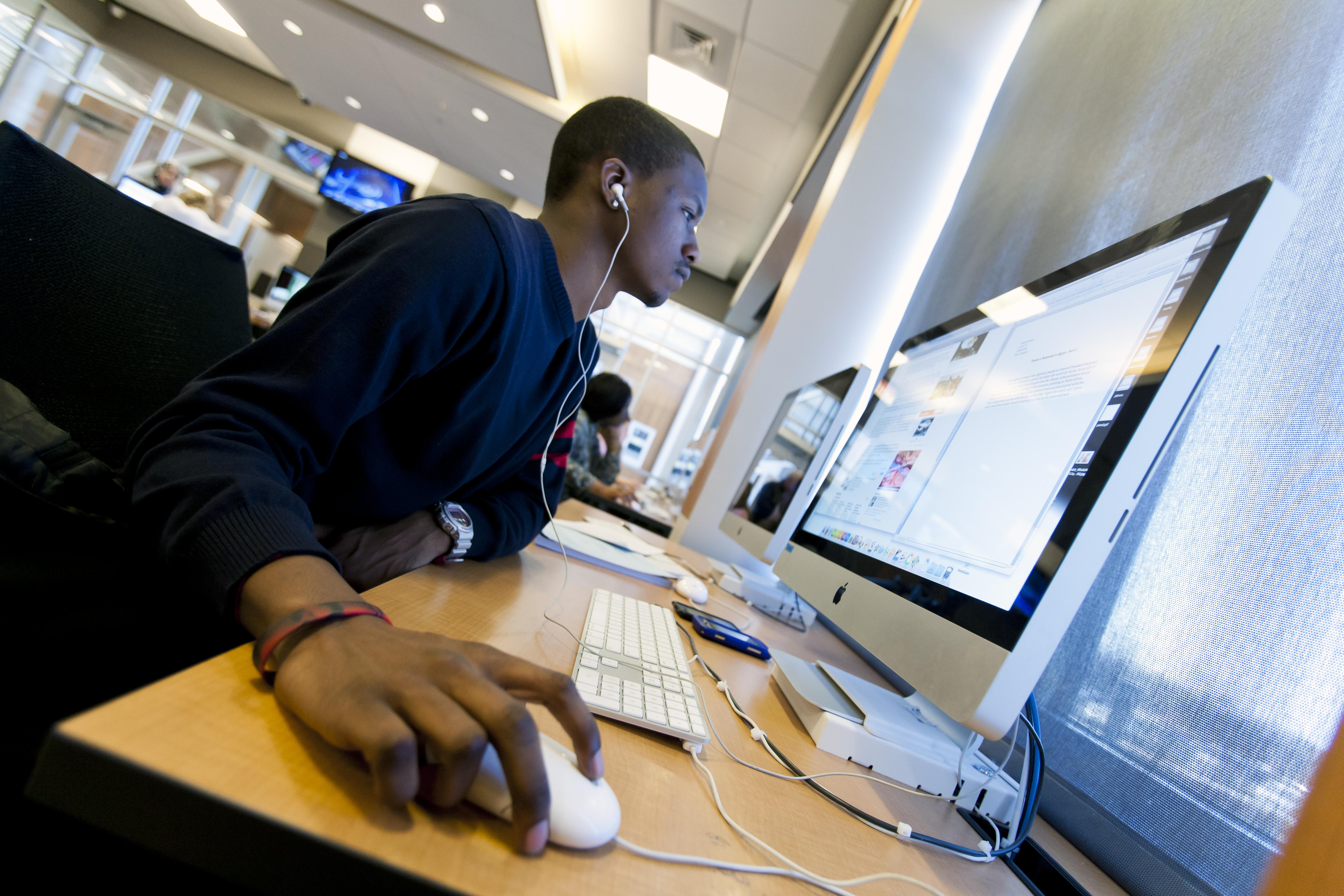 Student a desktop computer with headphones